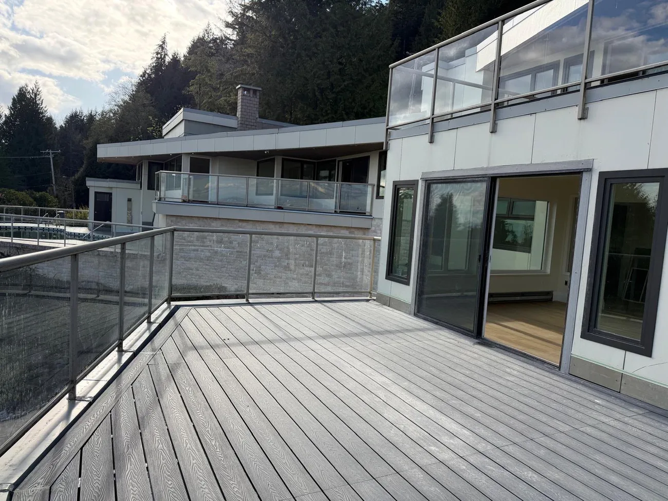 Composite deck with glass railing and exterior home access