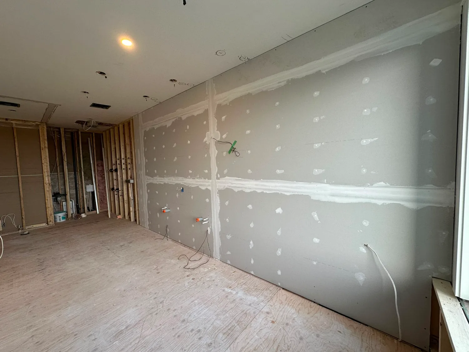 Drywall boards installed with visible taping and mudding preparation